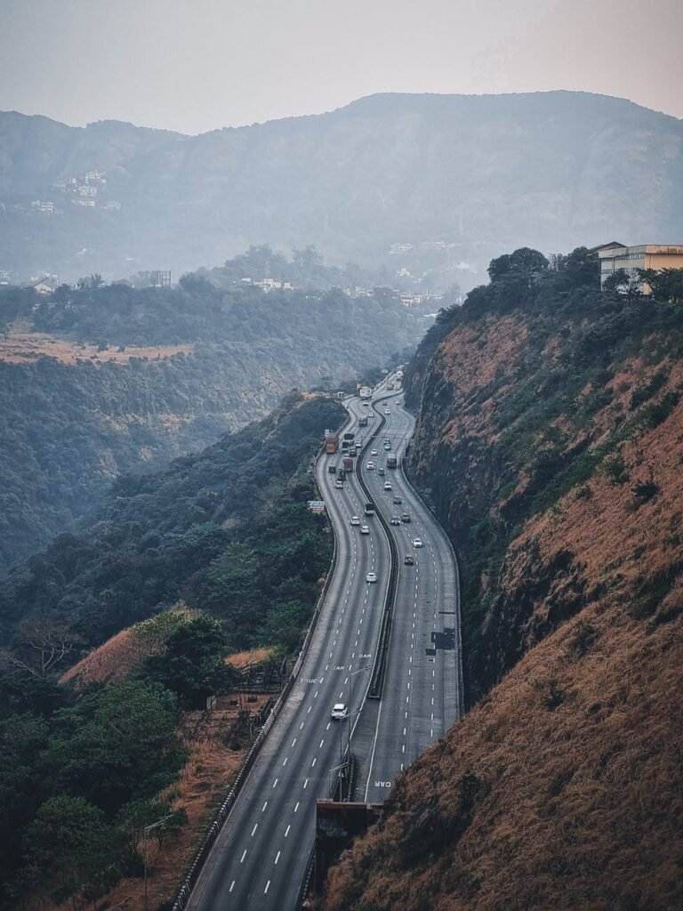 Aerial view of scenic highway winding through Lonavala hills in India, showcasing nature's beauty.